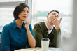 © DragonImages - Businesswoman listening speaker with interest when her coworker is yawning at business training