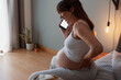 © ikostudio - Pregnant woman calling medical assistance