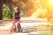 Happy cute girl with bicycle in the summer park. Beauty nature scene with healthy outdoor lifestyle. Happy kid having fun outdoor at summer. Happiness and harmony