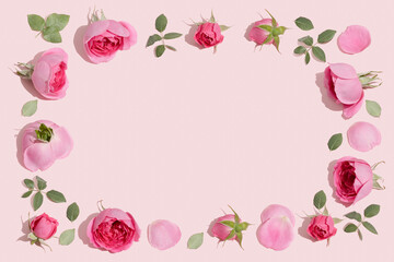 Wall Mural - Creative flowers composition. Vintage frame made of pink rose flowers on pastel pink background. Minimal flat lay.