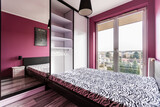 Fototapeta Storczyk - Stylowa sypialnia z dużym łóżkiem i fioletowymi ścianami