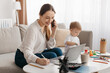 © Prostock-studio - Happy business mother working at home while her little son playing next to her, lady talking on phone and taking notes