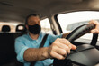 © Prostock-studio - Man in facemask driving new car in city