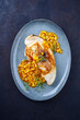 Fried swordfish steak with mango chutney and herbs served as top view on a design plate