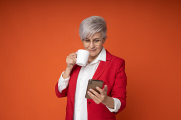 Wall Mural - stylish woman in red jacket with mobile phone and cup of coffee