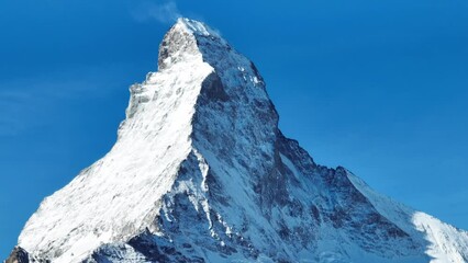 Wall Mural - Scenic view of snowcapped Matterhorn mountain peak. Beautiful snow covered white landscape against sky. Alpine region during winter.