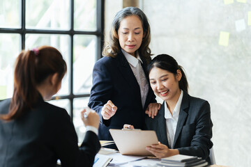 Wall Mural - Group of young business people working and communicating while sitting at the office desk together, Successful business team sitting in office and planning work.