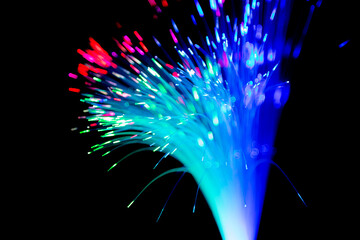 Wall Mural - Close up of blurred light fiber optics for communication technology network