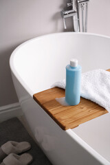 Wall Mural - Bottle of bubble bath with foam and towel on tub in bathroom