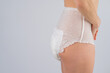 Side view of a Woman in adult diapers on a white background. Incontinence problem. 