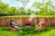 funny cat and dog relaxing at backyard and having picnic with bbq