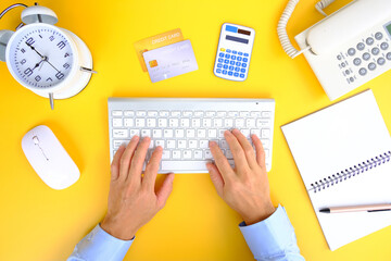 Poster - Business hand typing on keyboard, Flat lay, top view with copy space. A bank notepad and a pen are on top of an office desk table containing computer tools