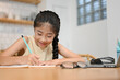 © bongkarn - Lovely pretty Asian preteen girl doing a homework at desk