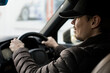 Young smiling happy taxi driver mockup selective focus assistant caucasian European male in a premium luxury car photo banner holding steering wheel.