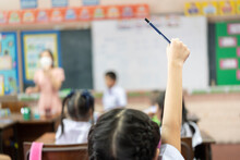 Selective Focus On Hand. Children Or Schoolkids Or Students Raising Hands Up With Asian Teacher Wearing Protective Face Mask In Classroom At School While