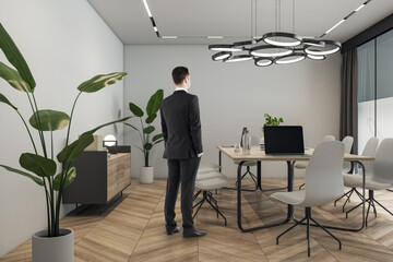 Aufkleber - Attractive thoughtful young european business man standing in modern meeting room interior with window and city view, furniture. CEO and worker concept.