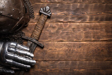 Ancient Knight Sword And Armor On The Wooden Table Flat Lay Background With Copy Space.