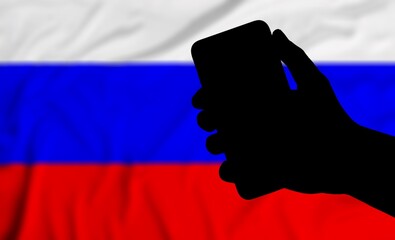 Sticker - Silhouette hand with smartphone against the background of the Russian flag. The concept  Russia.