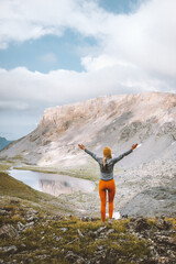 woman hiking alone raised hands enjoying mountain lake view travel adventure outdoor freedom active 