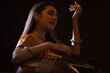 © IndiaPix - Close-up view of a female musician performing with Tanpura at concert