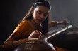 © IndiaPix - Close-up view of a female musician performing with Tanpura at concert