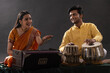 © IndiaPix - Man and woman performing together with harmonium and Tabla in a classical musical concert