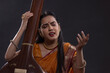 © IndiaPix - Close-up view of a female musician performing with Tanpura at concert