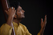 © IndiaPix - Close-up view of a male musician performing with Tanpura at concert