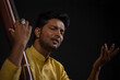 © IndiaPix - Close-up view of a male musician performing with Tanpura at concert