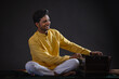 © IndiaPix - Portrait of cheerful young man performing with Harmonium at concert