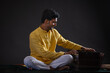 © IndiaPix - Portrait of cheerful young man performing with Harmonium at concert