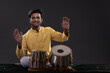© IndiaPix - Portrait of cheering young man performing with Tabla on stage