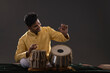 © IndiaPix - Portrait of cheering young man performing with Tabla on stage