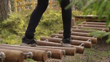 Person Walking Over Dangerous Suspension Bridge Made Of Wood, Low Leg Shot