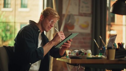 Fototapete - Focused Male Designer Drawing on Tablet with Stylus Pen while Working with Inspiration in Modern Loft Place. Modern Artist Creating Design of Shoes. Modern Freelancer at Remote Work Concept