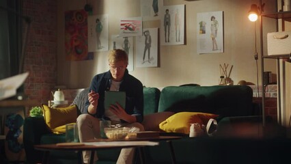 Aufkleber - Caucasian Male Designer Draw on Digital Tablet, while Laying at Sofa at Relaxed Pose. Loft Modern Room. Smart People and New Generation Concept
