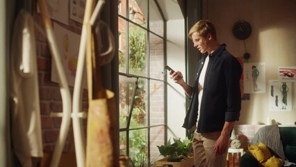 Aufkleber - Professional Creative Man Walking at his Home Studio Using Smartphone, Man Texting at Mobile Phone, Browsing Through Internet, Social Networks, Media. Millennial People Concept