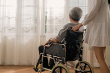 Smiling Nurse Pushing Senior Asian Man Sitting On Wheelchair To Look At Outside Garden View,asian Elder Male Sit In Wheelchair Talking To His Home Caregiver In Living Room At Home Healthy Care At Home