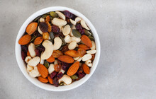 trail mix with nuts and cranberries on rustic grunge background with copy space