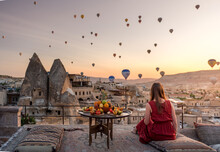Girl In Red Dress Watches Hot Air Balloons Over Cappadocia