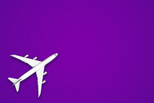 Flat Lay Design Of Travel Concept With Plane On Purple Background For Copy Space
