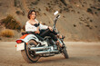 A beautiful sexy adult woman with a high heels, confidently posing sitting on motorcycle. The concept of Motorcyclist Day