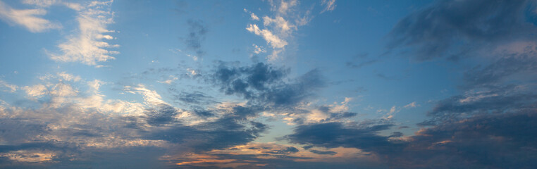 White, grey and blue clouds in evening sky, sunset panoramic background