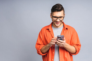 great news today! happy smiling young ukrainian man in casual standing and using mobile phone isolat