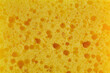 Dishwashing sponge texture close up photo. Yellow sponge pattern macro photography.