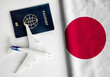 Flag of Japan with passport and toy airplane. Flight travel concept
