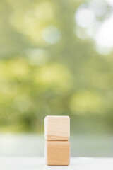 Canvas Print - Wooden cubes from natural wood on a green summer background. Copy, empty space for text