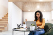 © Prostock-studio - Woman sitting at desk, using computer and writing in notebook