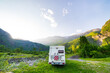 © fabio lamanna - Camper van in the mountains, the Alps, Piedmont, Italy. Sunset dramatic sky and clouds, unique highlands and rocky mountains landscape, alternative vanlife vacation concept.
