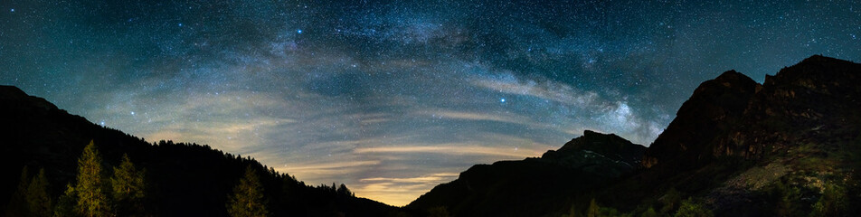 Wall Mural - milky way arch and starry sky on the alps. panoramic view, astro photography, stargazing. light poll